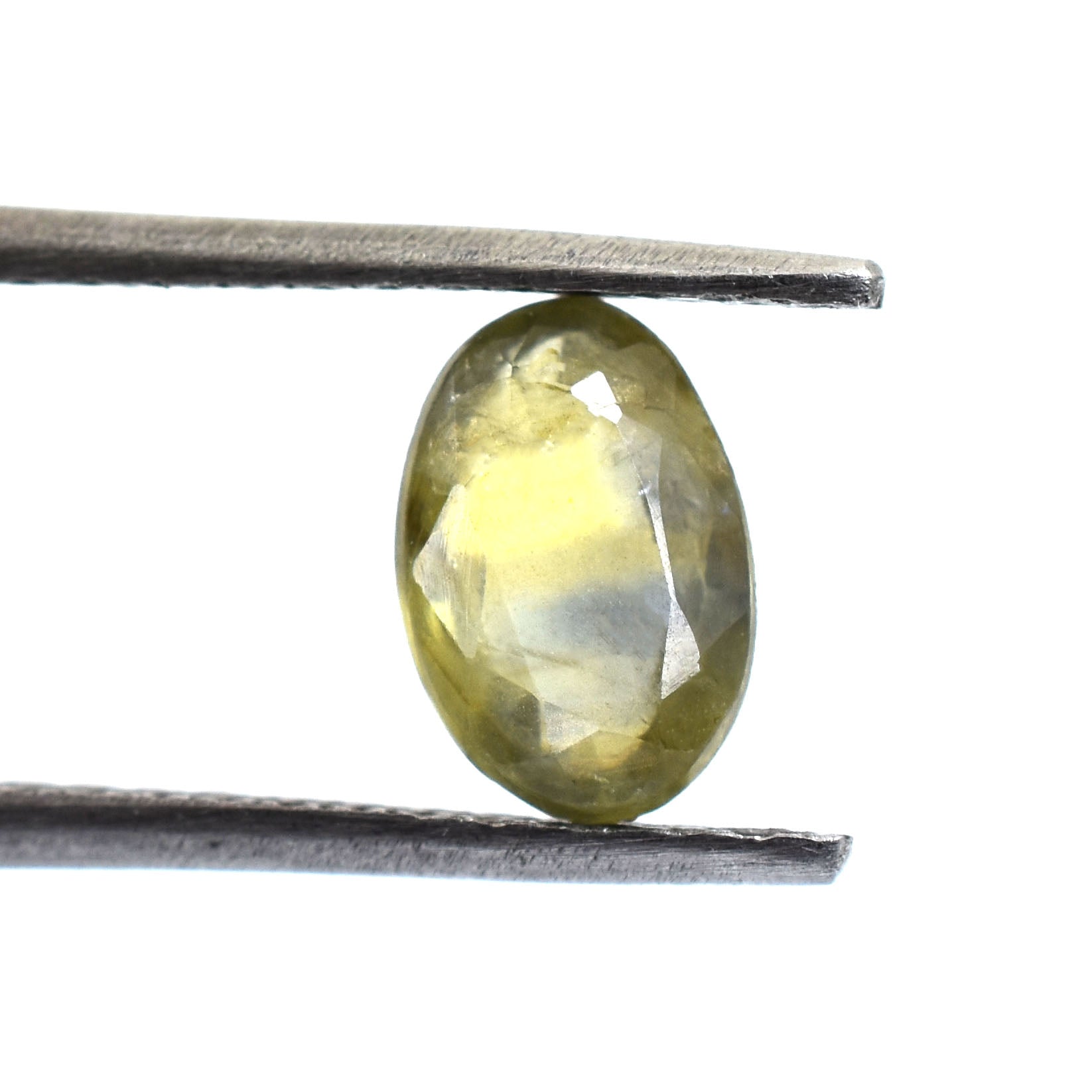 Oval-shaped yellow gemstone held between metal tweezers.