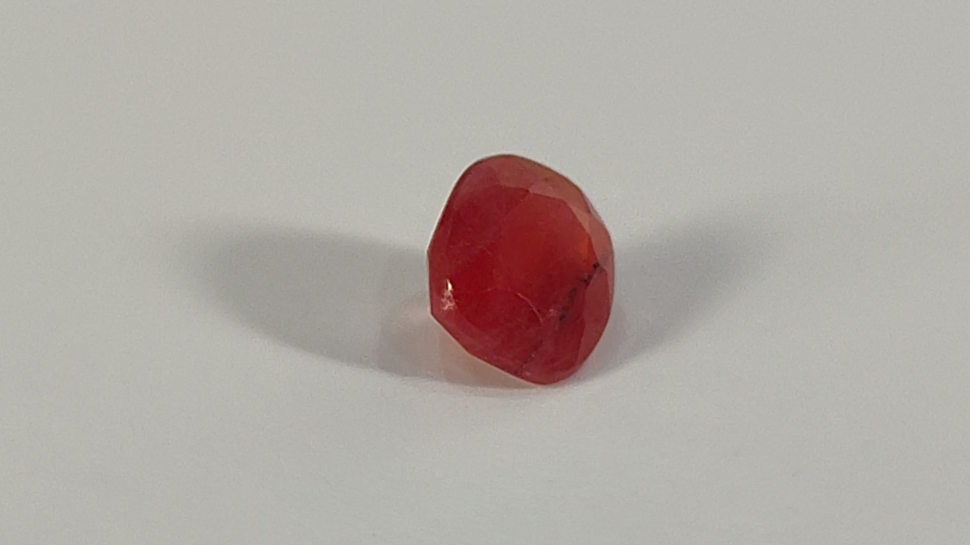 Red, translucent gummy candy or jelly bean.