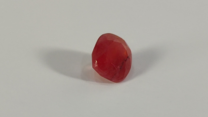 Red, translucent gummy candy or jelly bean.