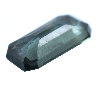 Faceted blue-green gemstone with an elongated rectangular shape.