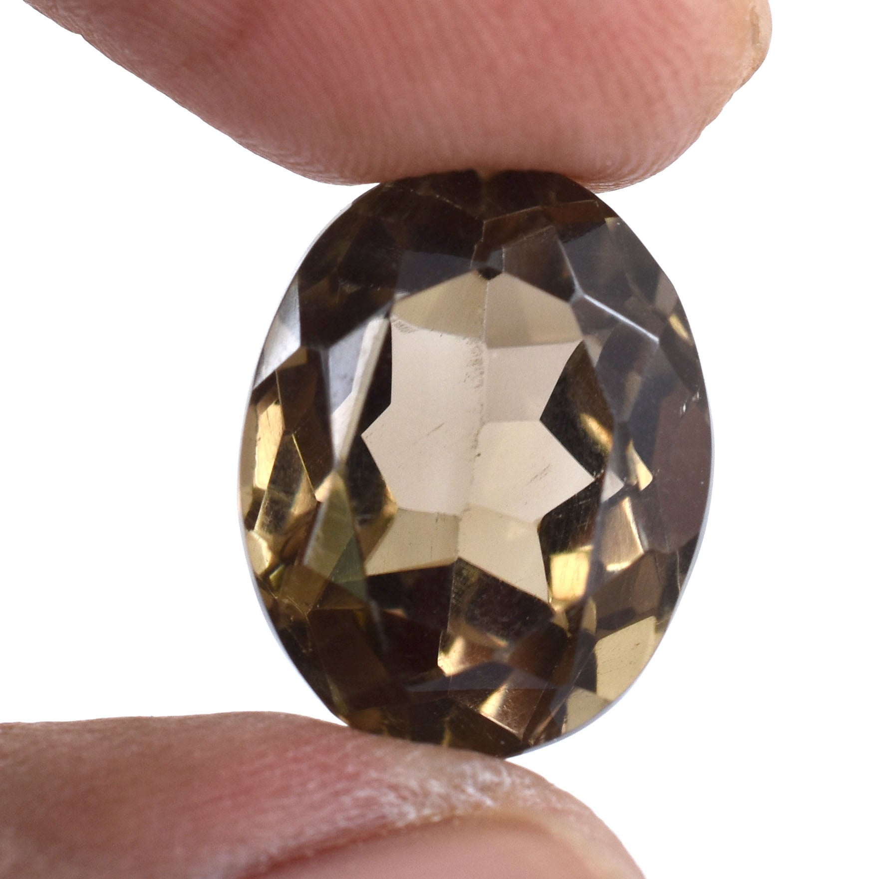 Faceted oval gemstone held between two fingers, with a smoky brown color.